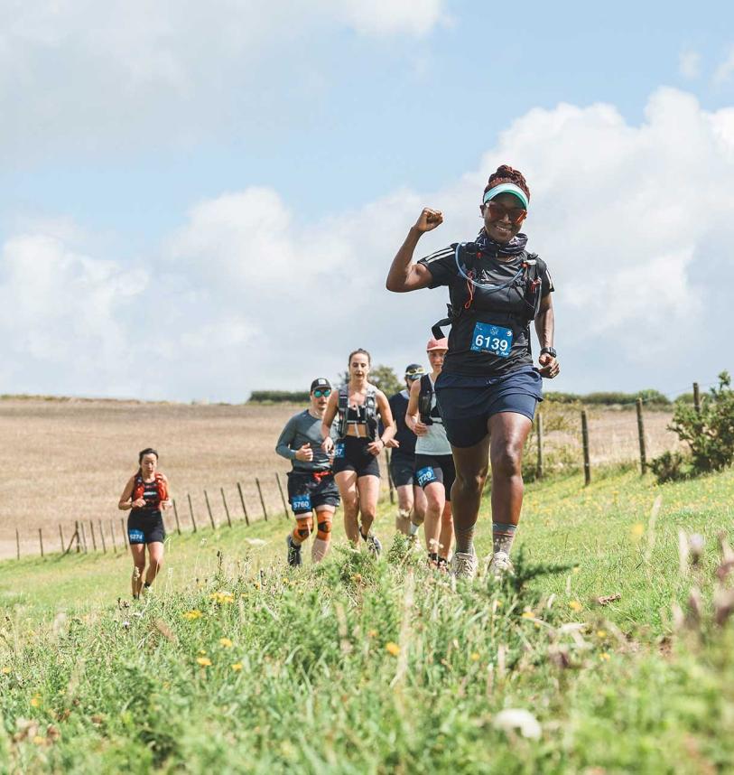 Participants running through fields during the Maverick race