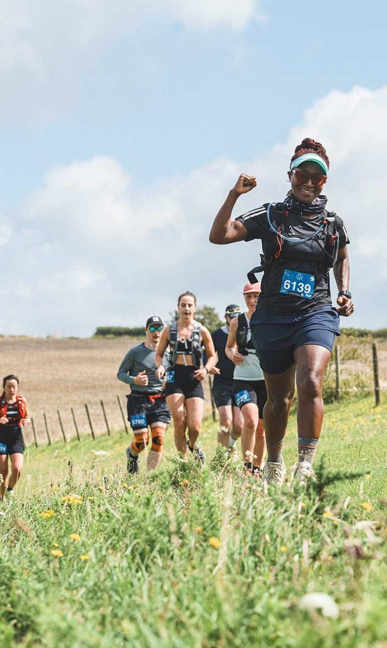 Participants running through fields during the Maverick race