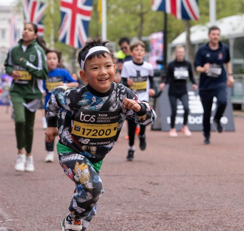 Participants run down The Mall as they finish the TSC Mini London Marathon 